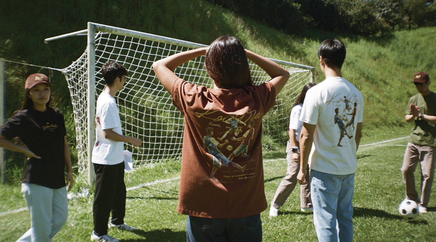 Pessoas vestindo pe&ccedil;as KoiWa em um campo, representando cultura, comunidade e movimento.